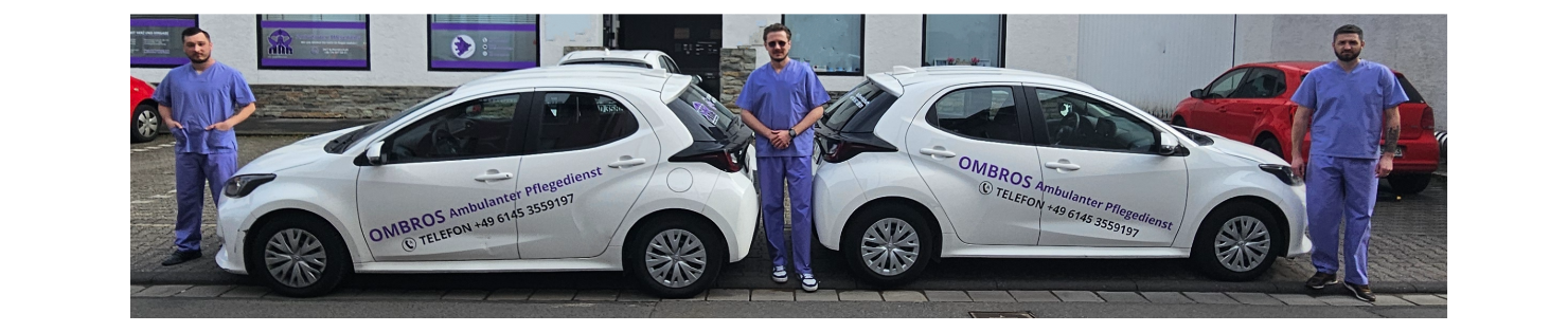 Zwei weiße Autos mit Logos, daneben stehen drei Männer in lilaner Pflegeruniform